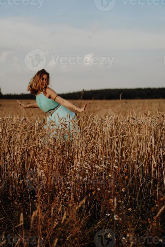 schöne junge Frau tanzt auf dem Feld foto