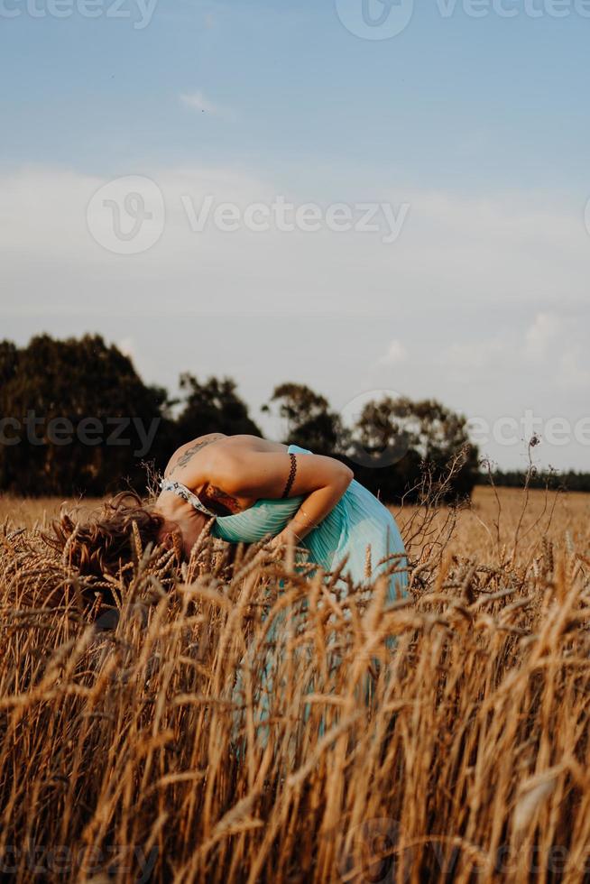 schöne junge Frau tanzt auf dem Feld foto
