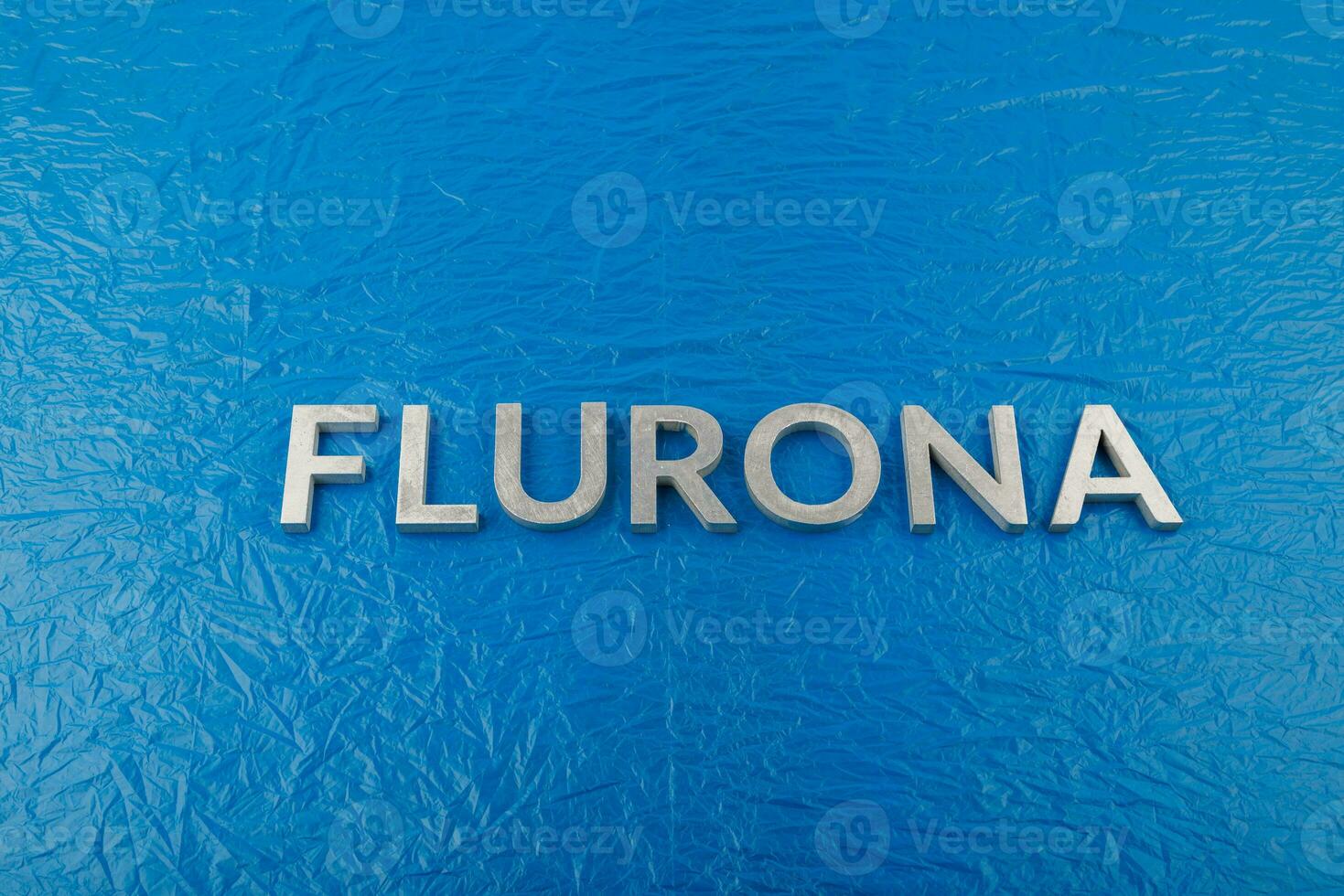 das wort flurona mit silbernen metallbuchstaben auf zerknittertem blauem kunststofffolienhintergrund foto