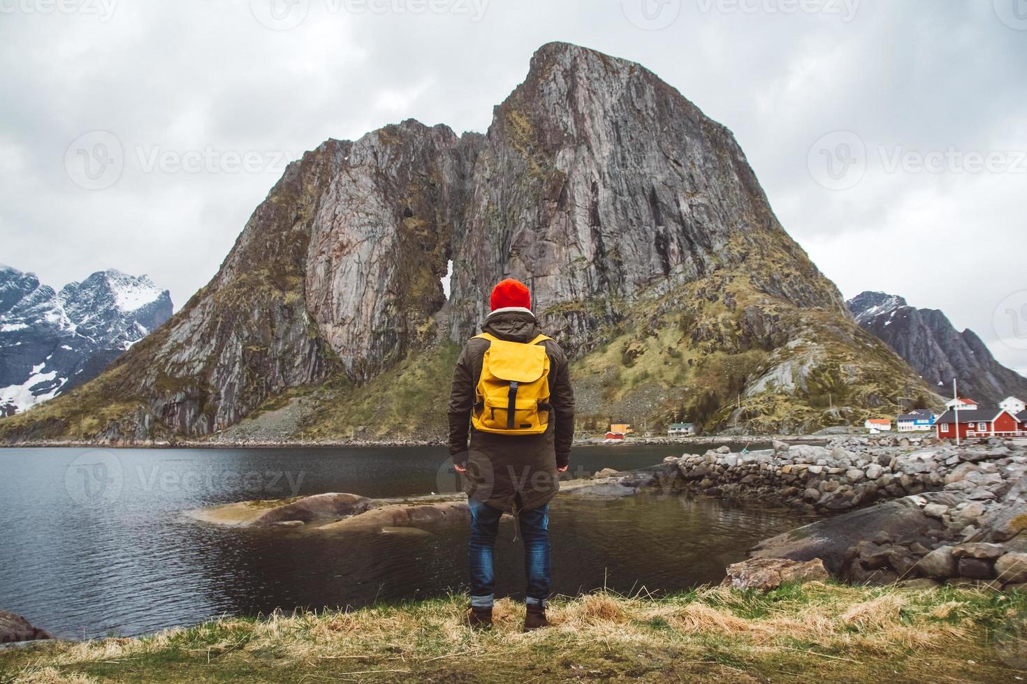 Reisender Mann mit Backpa stehend auf dem Hintergrund von Berg und See foto