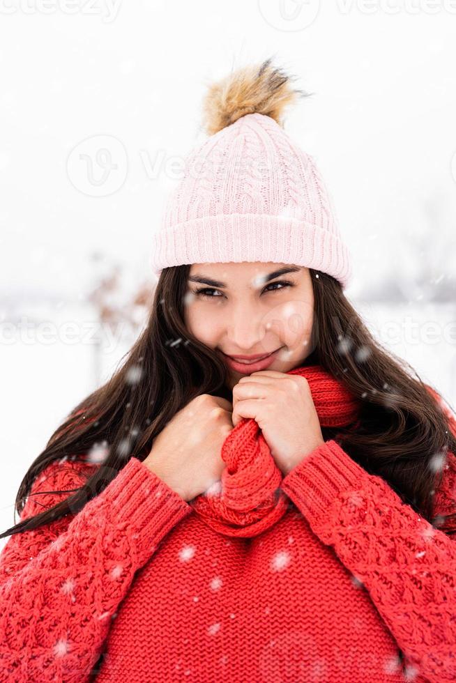 Porträt einer schönen lächelnden jungen Frau im Winter im Freien foto