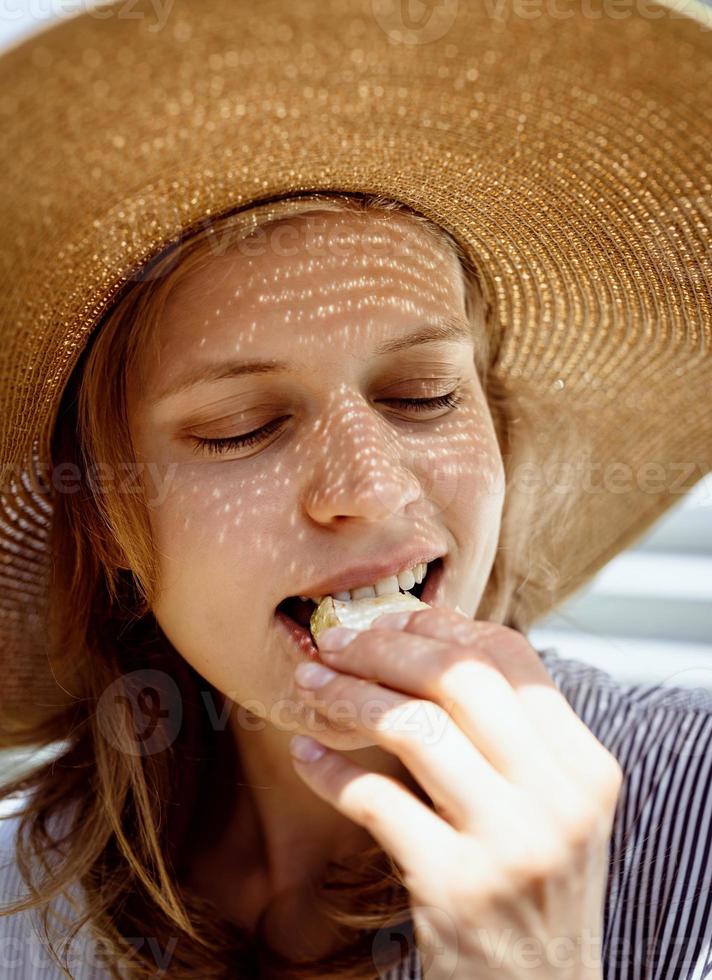 Kopfschuss einer Frau, die im Freien gegrilltes Gemüse isst foto