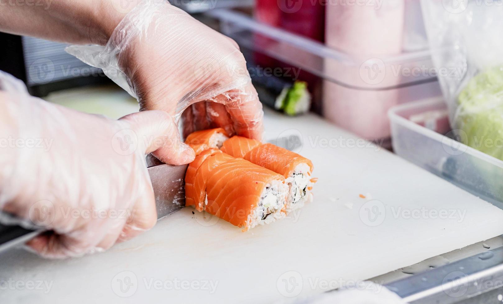 Sushi-Chef schneidet Brötchen foto