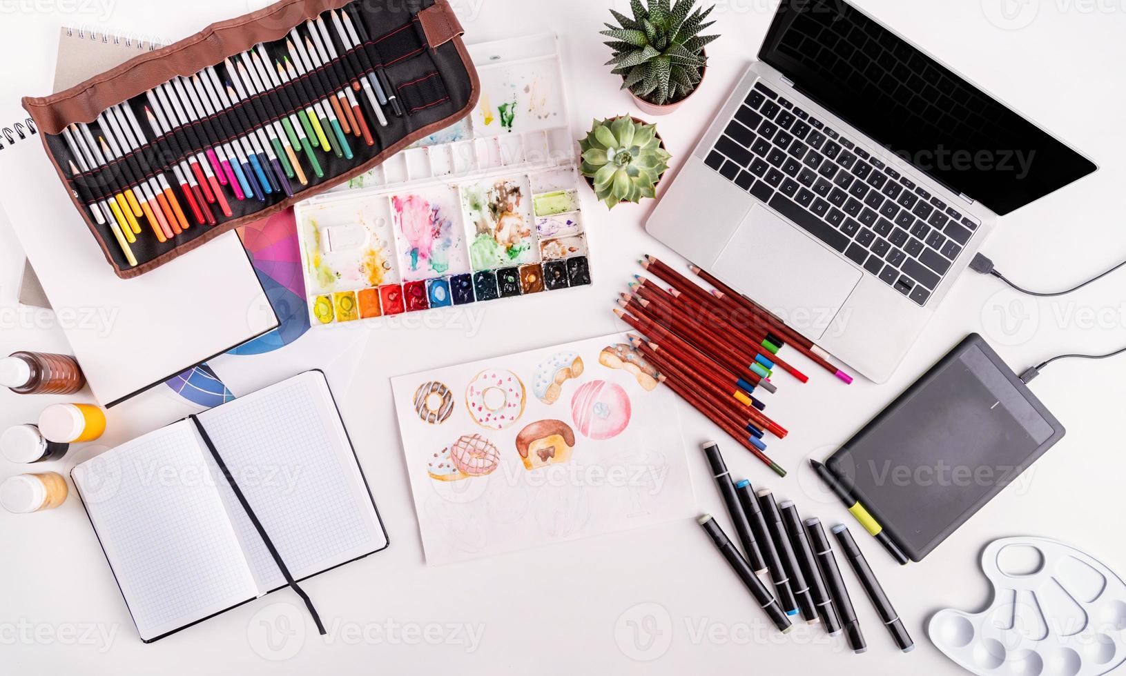 Künstlerarbeitsplatz mit Laptop, Tablet und Zeichenwerkzeugen foto