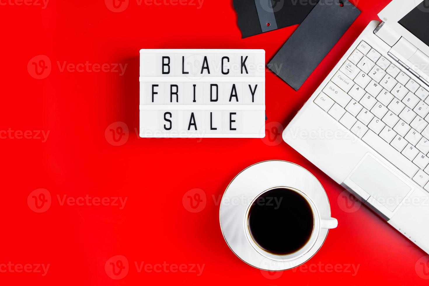 Black Friday-Verkaufskonzept. Laptop und Kaffeetasse auf rotem Grund. foto