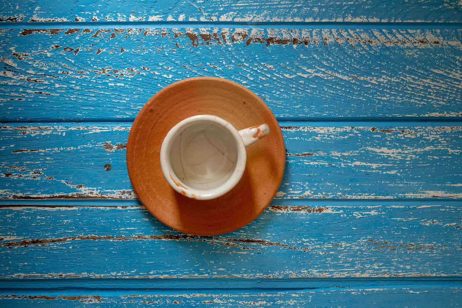 leere Kaffeetasse auf einem blauen ländlichen Holztisch foto