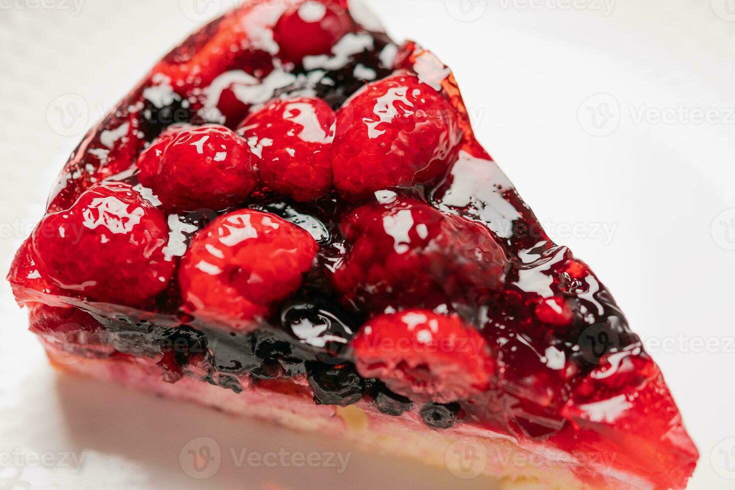 Stück von Kuchen mit Beeren, Himbeere, Erdbeere, Johannisbeere, auf ein Weiß Hintergrund, Nahansicht foto