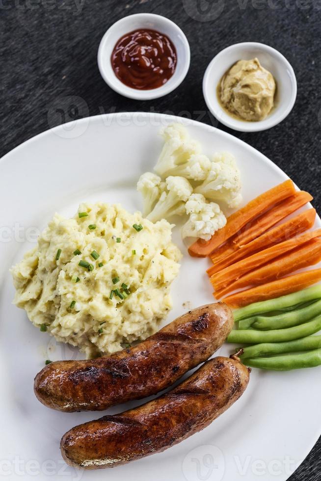 deutsche Wurst mit Kartoffelpüree und Gemüse einfache Mahlzeit foto