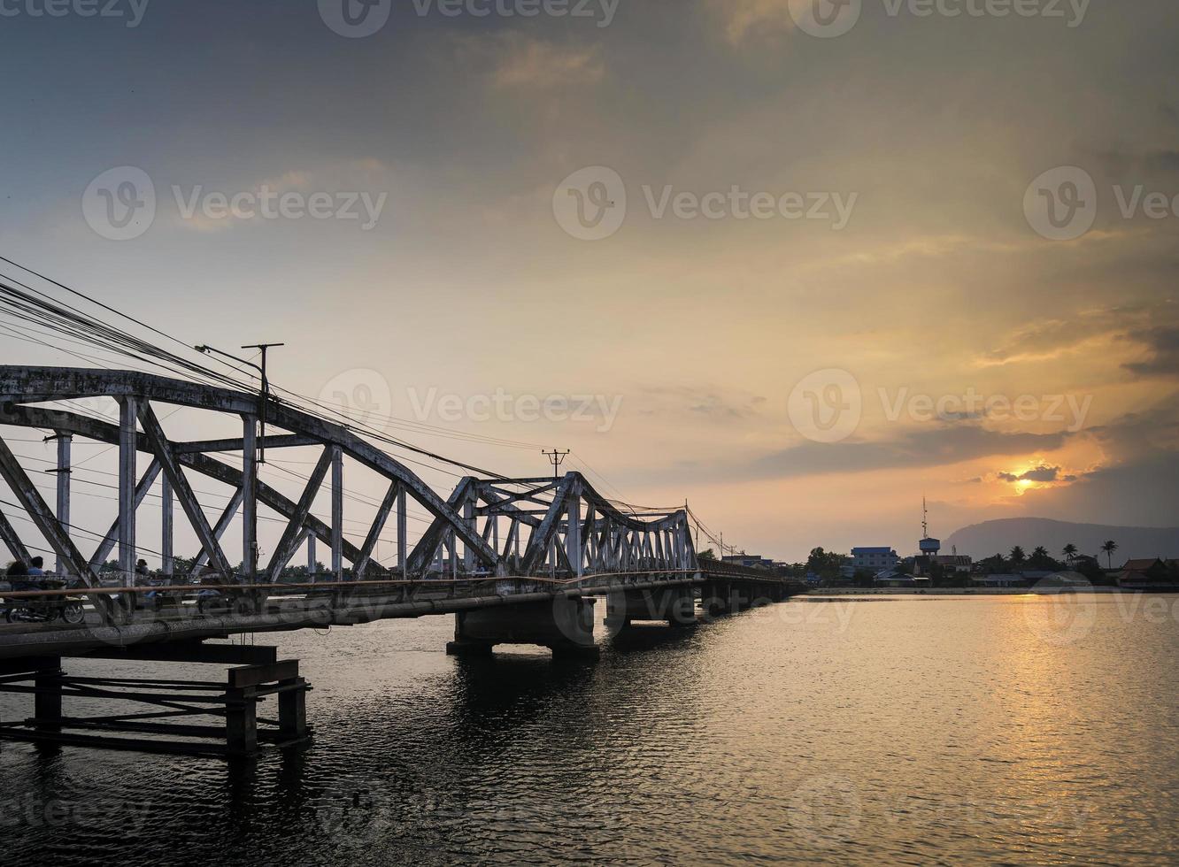 Wahrzeichen alte Brücke und Fluss bei Sonnenuntergang in Kampot Kambodscha foto