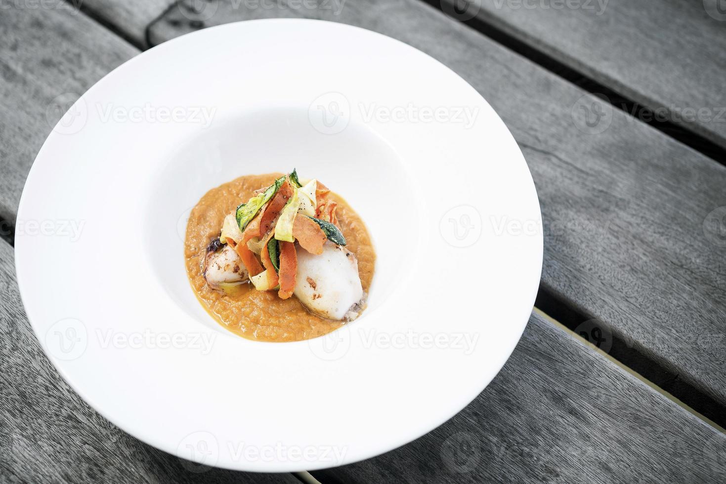 Gourmet gefüllter Tintenfisch mit Gemüse in würzigem Kürbis-Curry-Püree foto