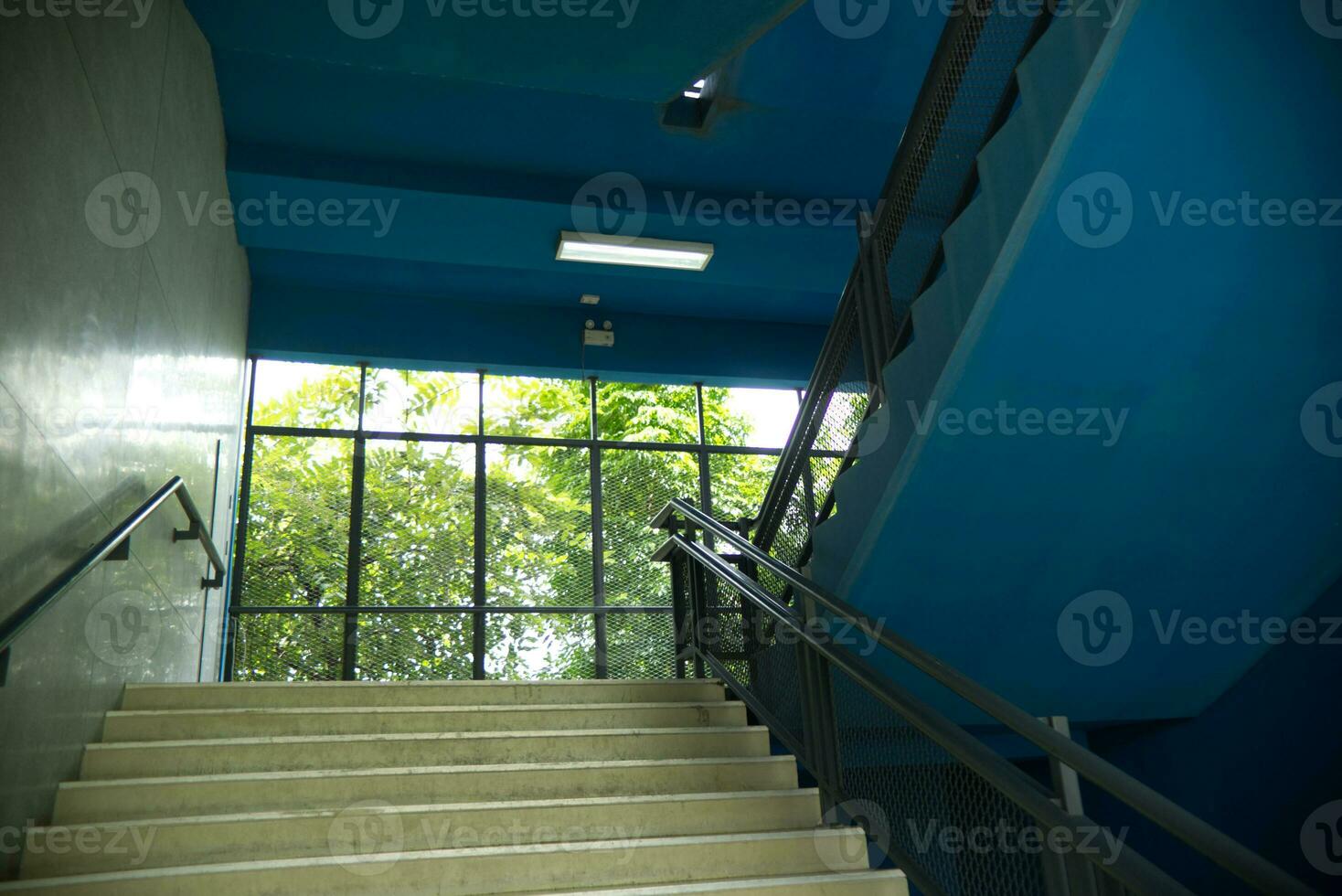 Blau Oberer, höher Seite Treppe mit sehen durch Mauer mit Baum und Sonnenlicht Hintergrund foto