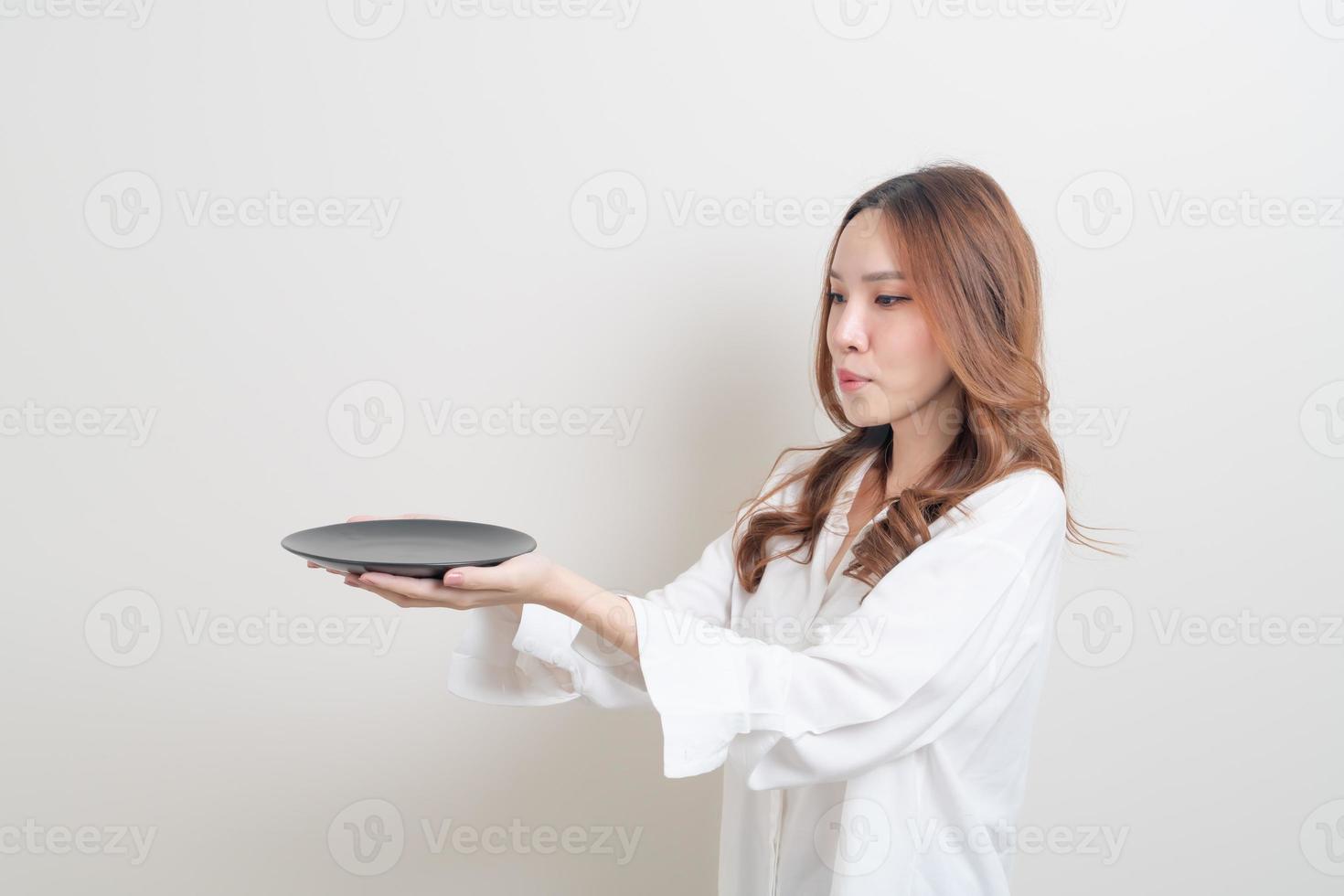 asiatische Frau mit leerem Teller foto