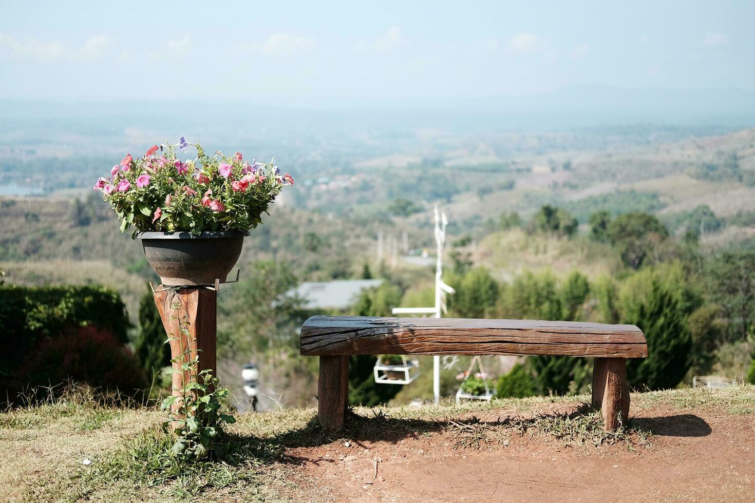 Blühen Blumen im hölzern Topf und Holz Bank Dekoration im Garten auf das Berg foto