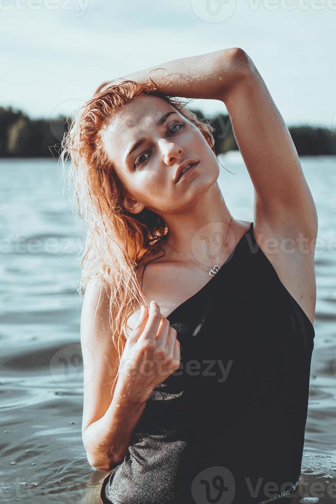 junge schöne Frau, die im Wasser steht. foto