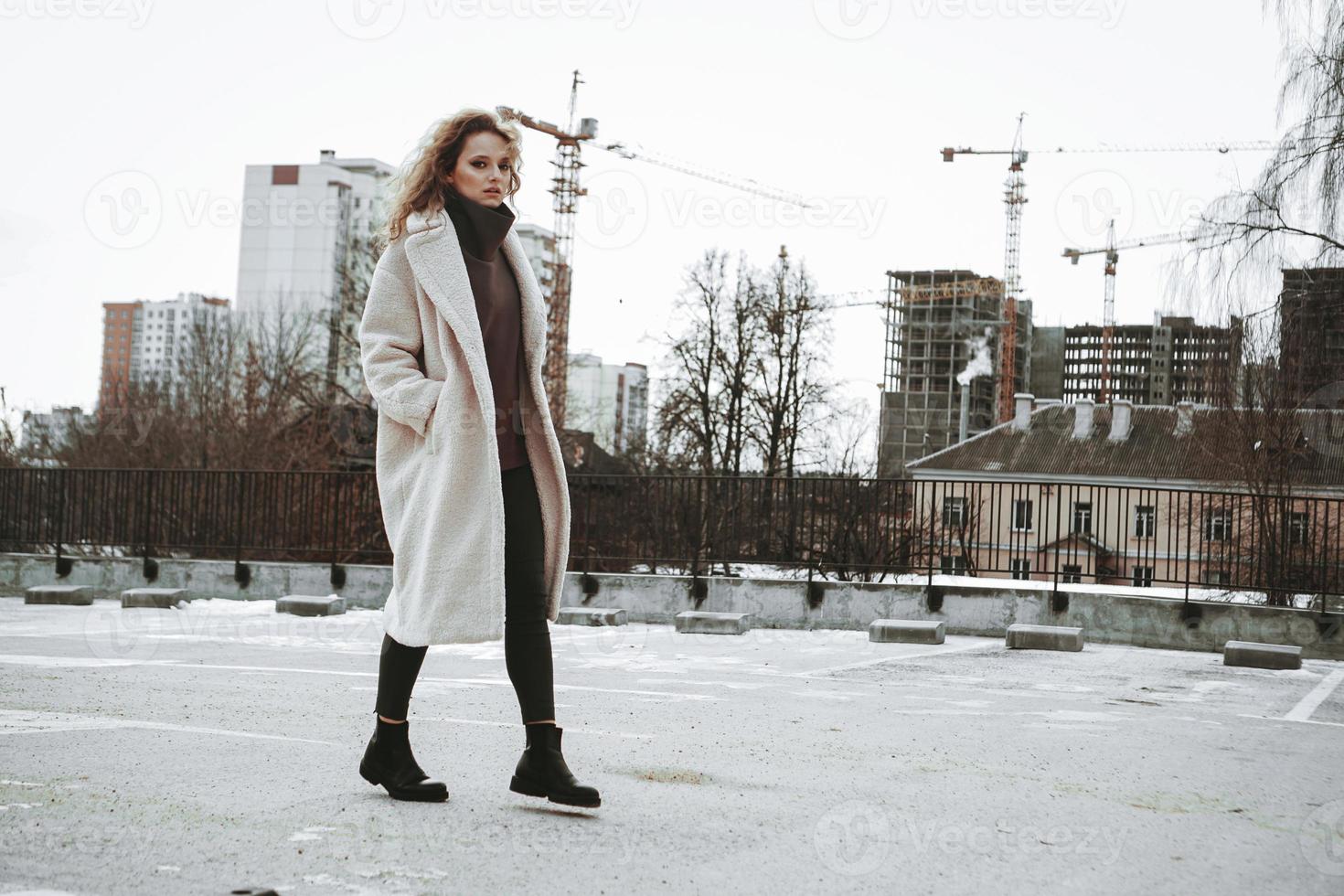 ein Mädchen mit roten Locken im weißen Kittel. Stadtbau foto