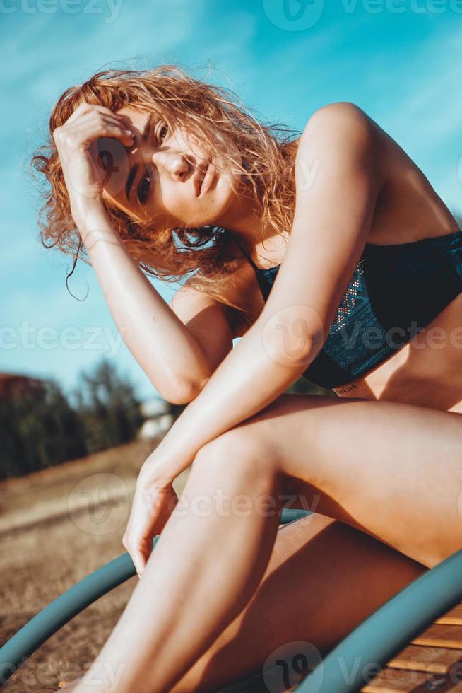 Porträt einer schönen jungen Frau im Badeanzug, die sich am Strand entspannt foto