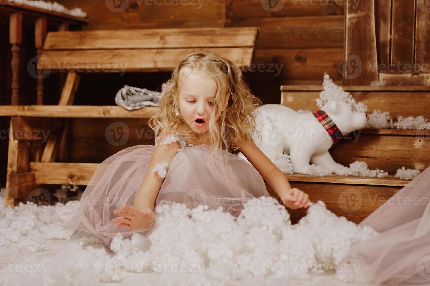 kleines Mädchen im rosa Kleid hält Kunstschnee foto