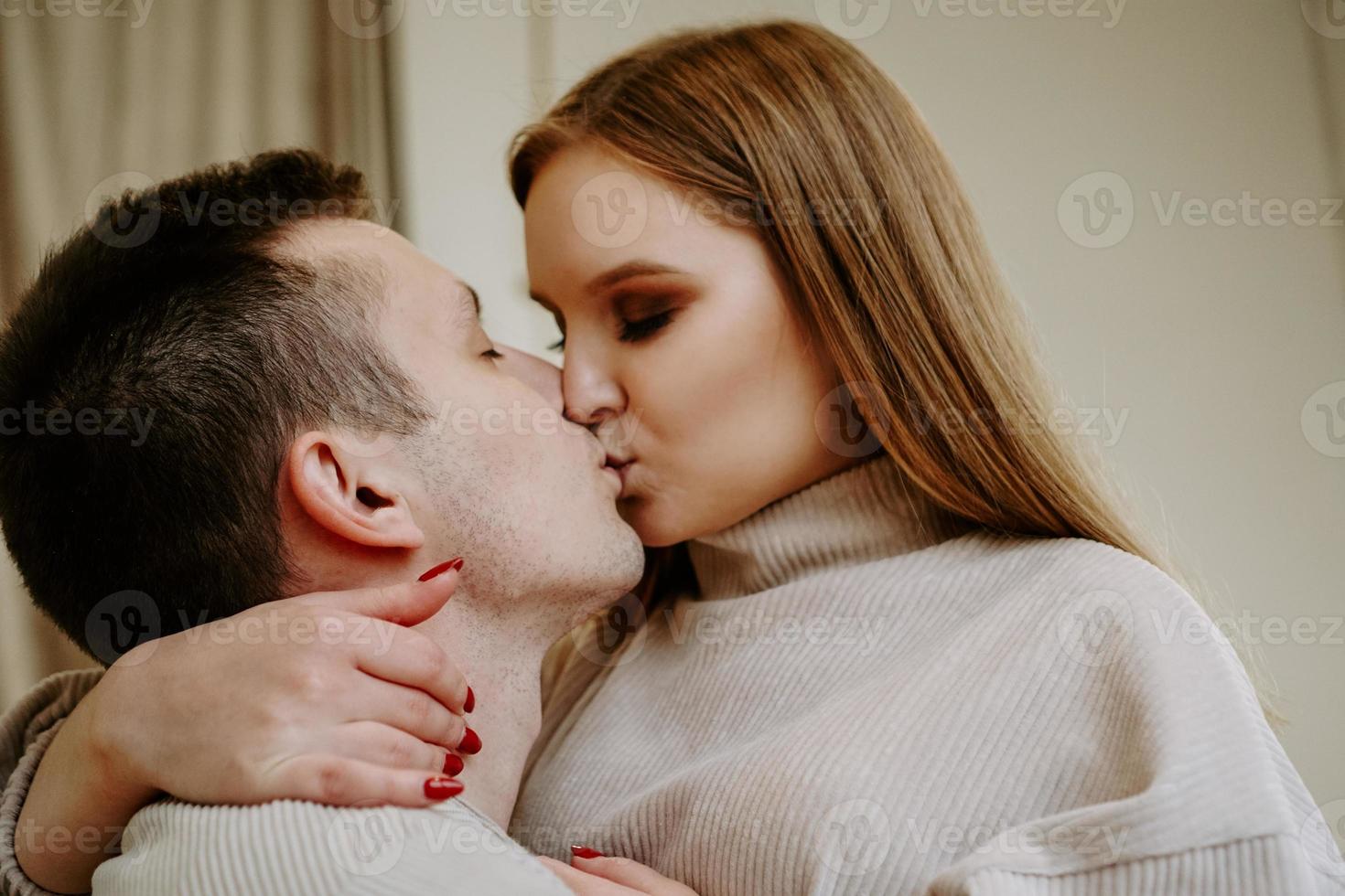 Nahaufnahmeporträt eines schönen jungen küssenden Paares im Bett zu Hause foto