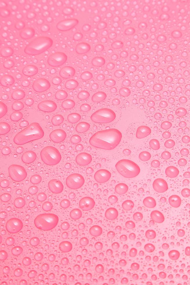 Nahaufnahme von Wassertropfen auf rosa Hintergrund foto