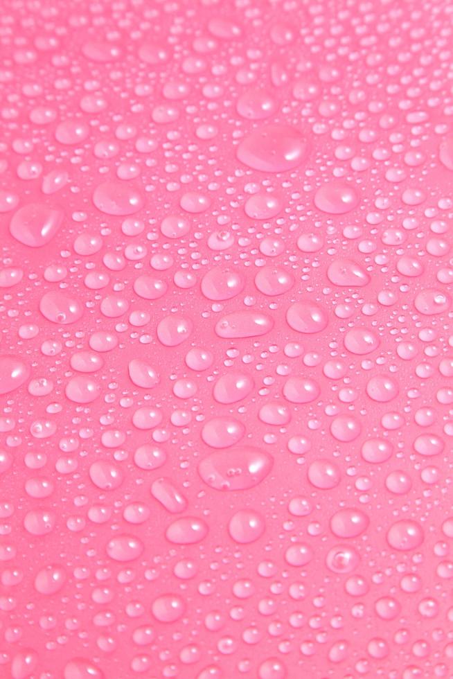 Nahaufnahme von Wassertropfen auf rosa Hintergrund foto