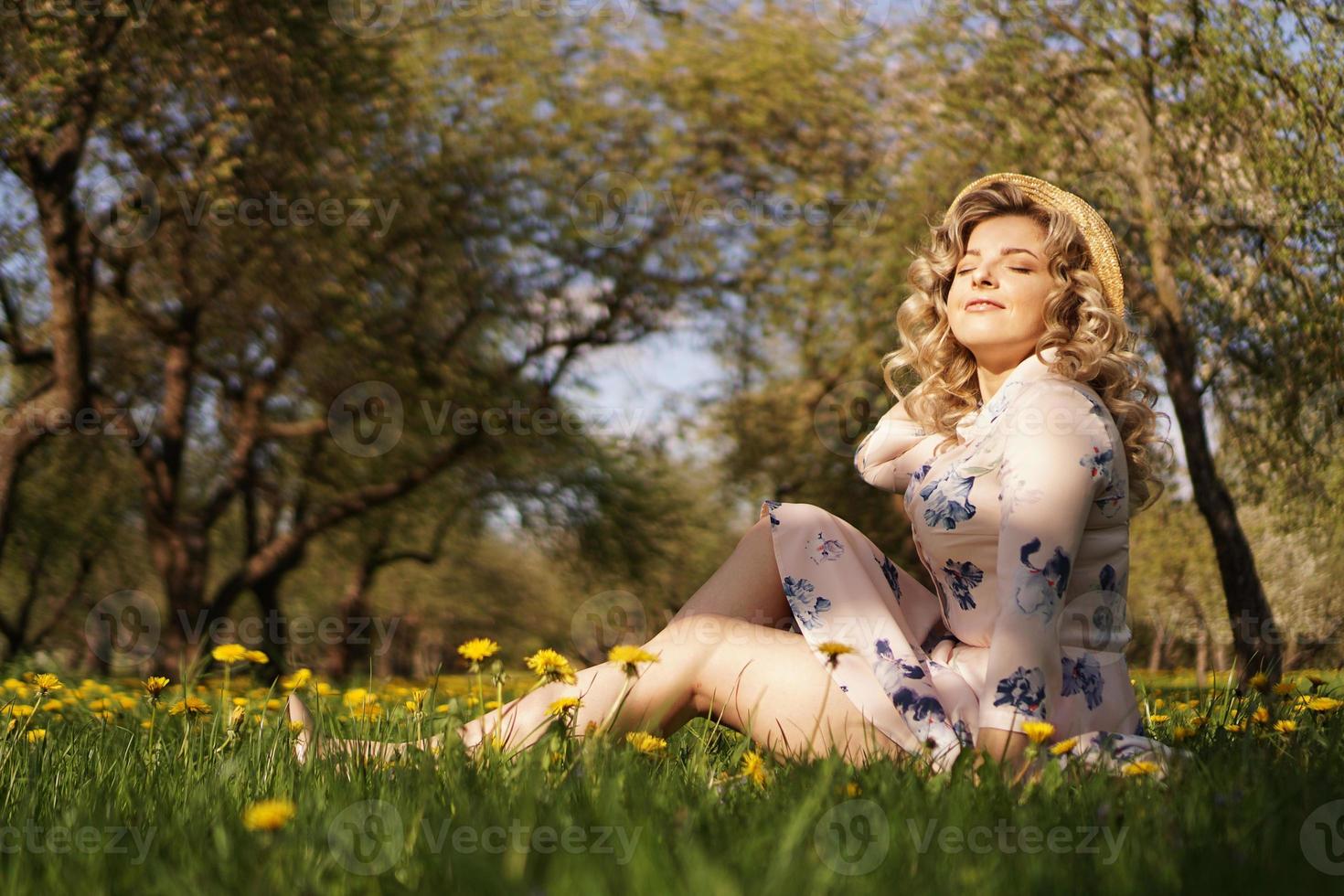 weibliches Porträt im Freien. Frau mit Strohhut auf einer Blumenwiese foto