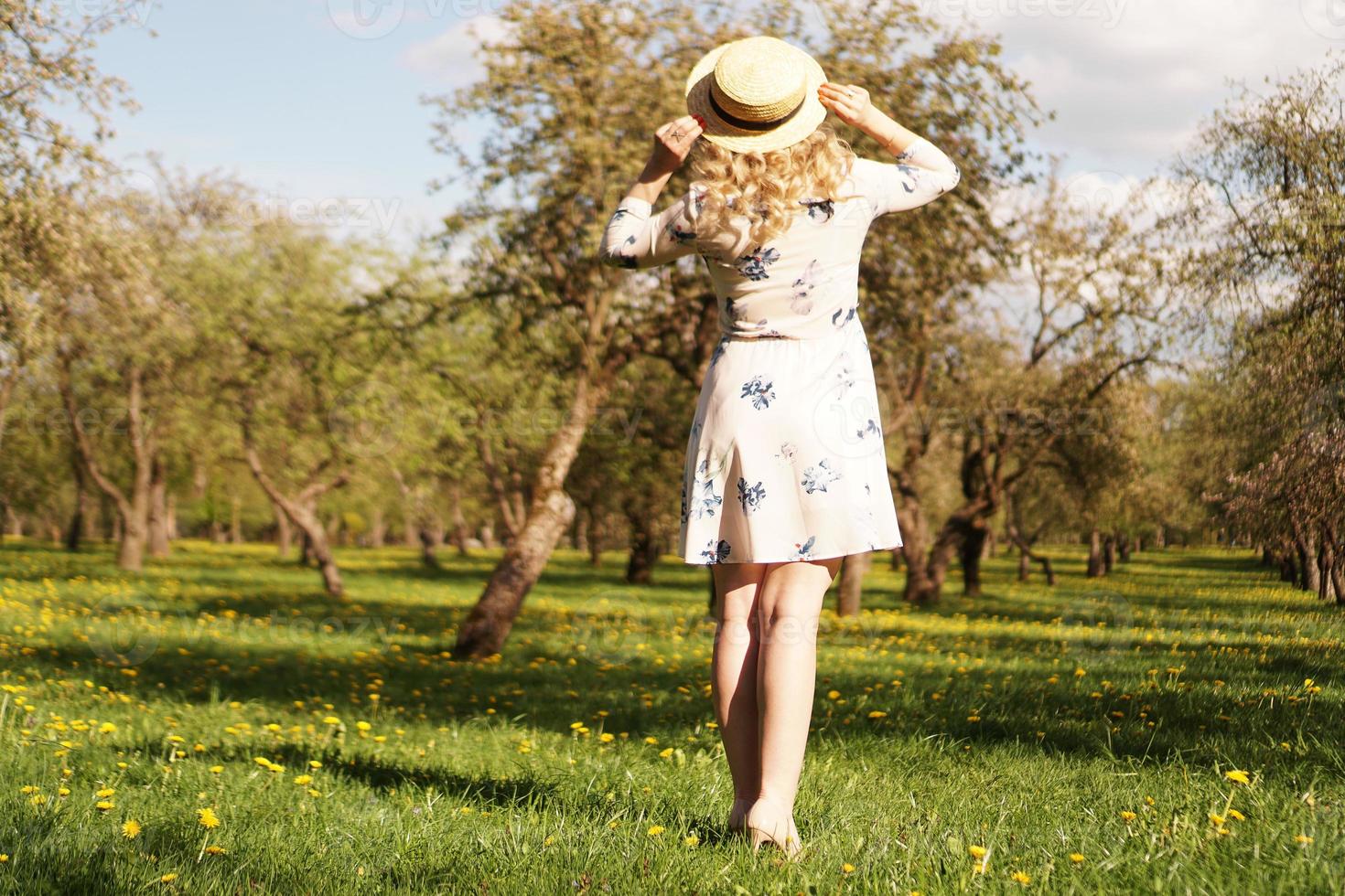 Mädchen mit Strohhut. Rückansicht. trendiges lässiges Sommer- oder Frühlingsoutfit foto