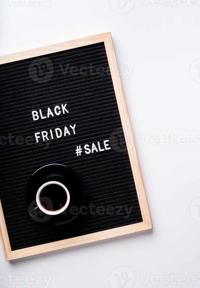 Text Black Friday Sale auf schwarzem Briefbrett mit Tasse Kaffee auf foto