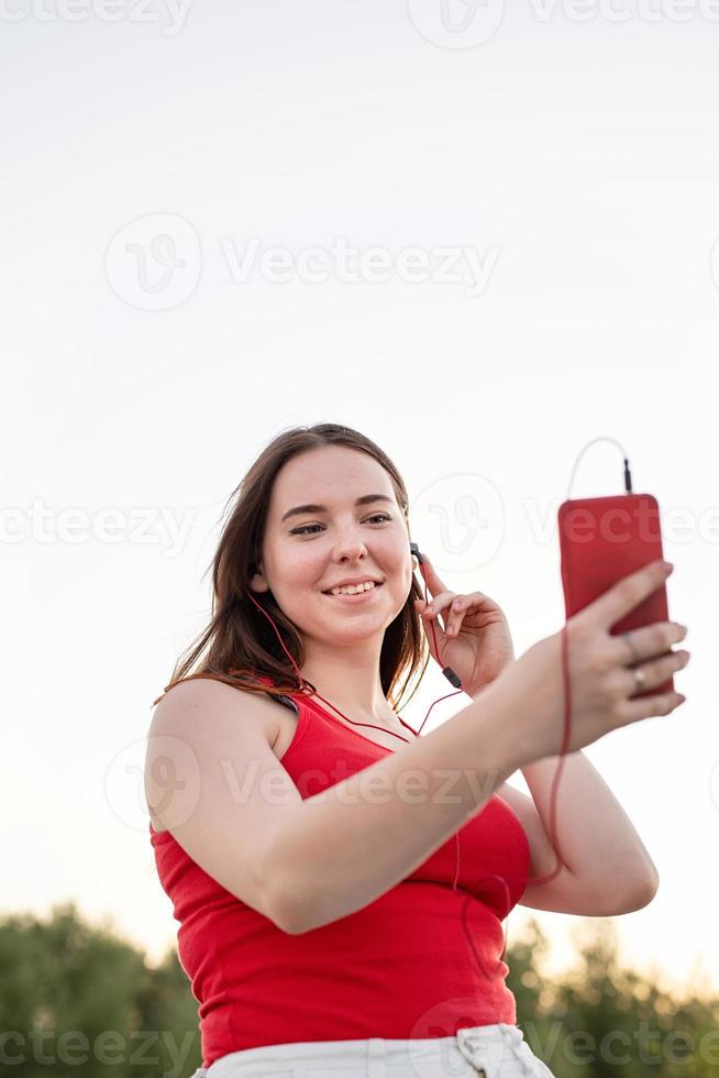 Teenager-Mädchen mit dem Handy und Kopfhörer foto