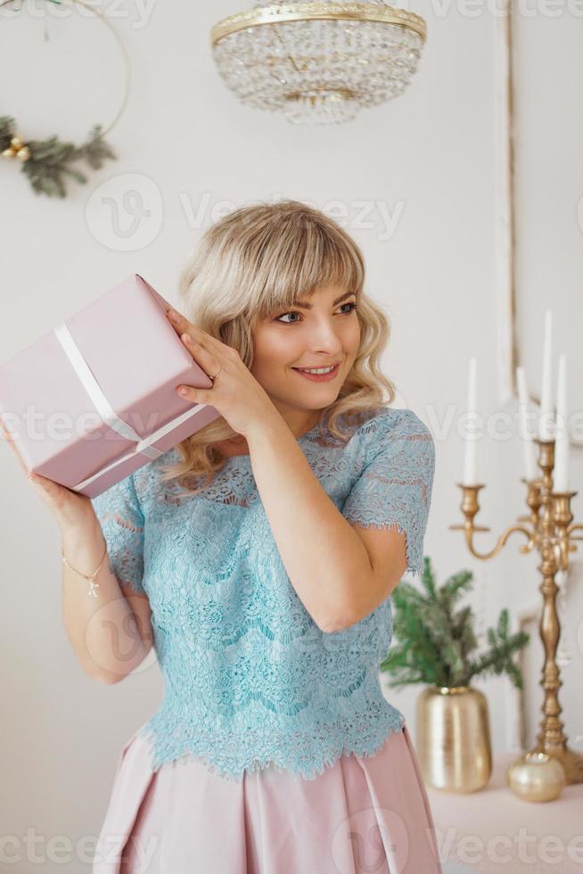 schöne junge frau mit elegantem stil mit rosa weihnachtsgeschenk foto