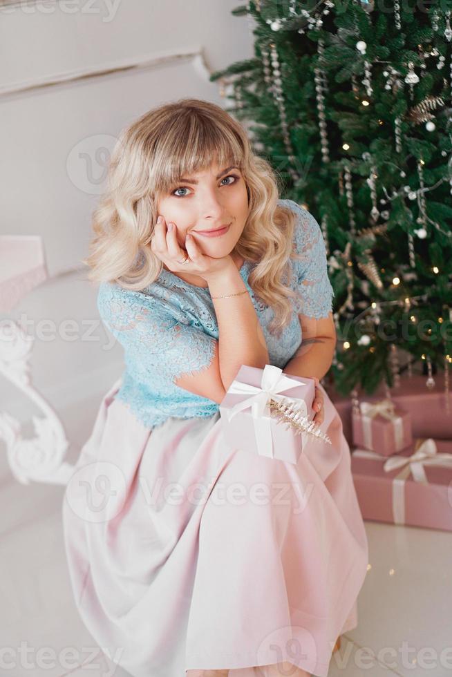 schöne junge frau mit elegantem stil mit rosa weihnachtsgeschenk foto