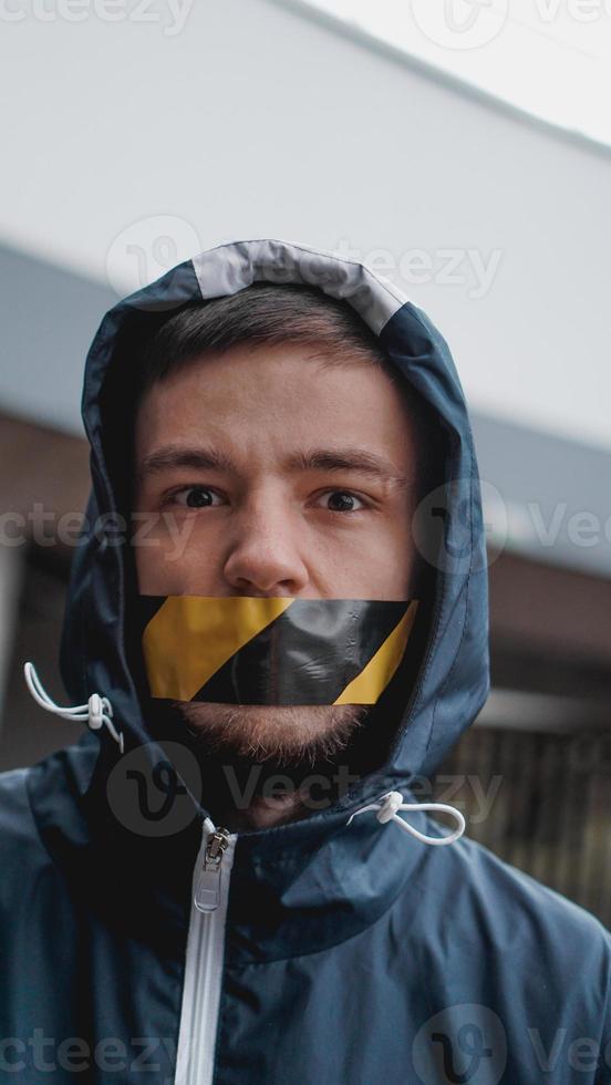 Mann mit Klebeband über dem Mund foto