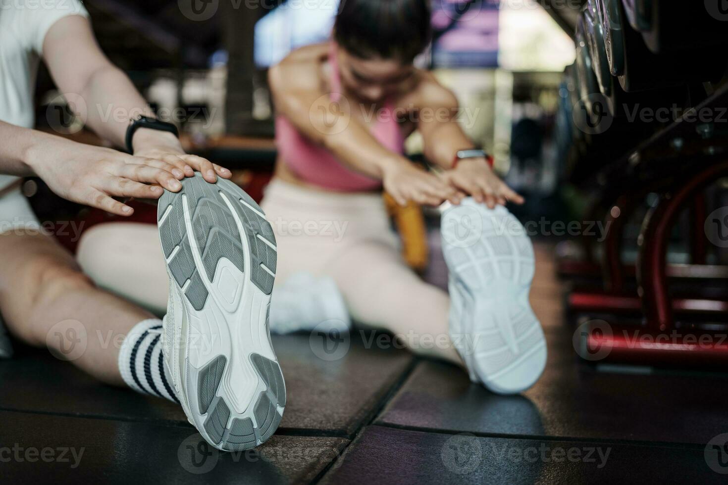 Fitness, Dehnen und zwei Frau beim Fitnessstudio zum ein warm oben trainieren, Ausbildung und Körper Wellness mit Übung. jung Sport weiblich oder Athlet auf Fußboden zu strecken Beine zum stark Muskel, Balance und Energie. foto