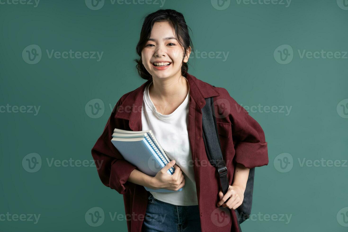 Porträt von ein schön asiatisch Schüler auf ein Grün Hintergrund foto