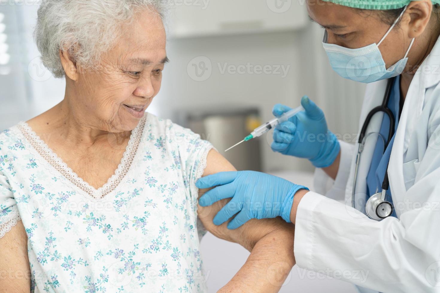 Ältere asiatische Seniorin, die gegen Covid-19 oder Coronavirus-Impfstoff erhält foto