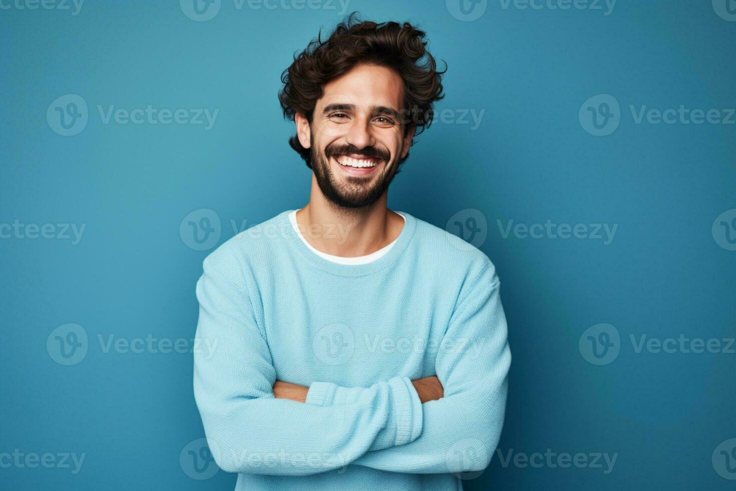 jung gut aussehend Mann mit Bart tragen beiläufig Sweatshirt und Brille Über Blau Hintergrund glücklich Gesicht lächelnd mit gekreuzt Waffen ai generativ foto
