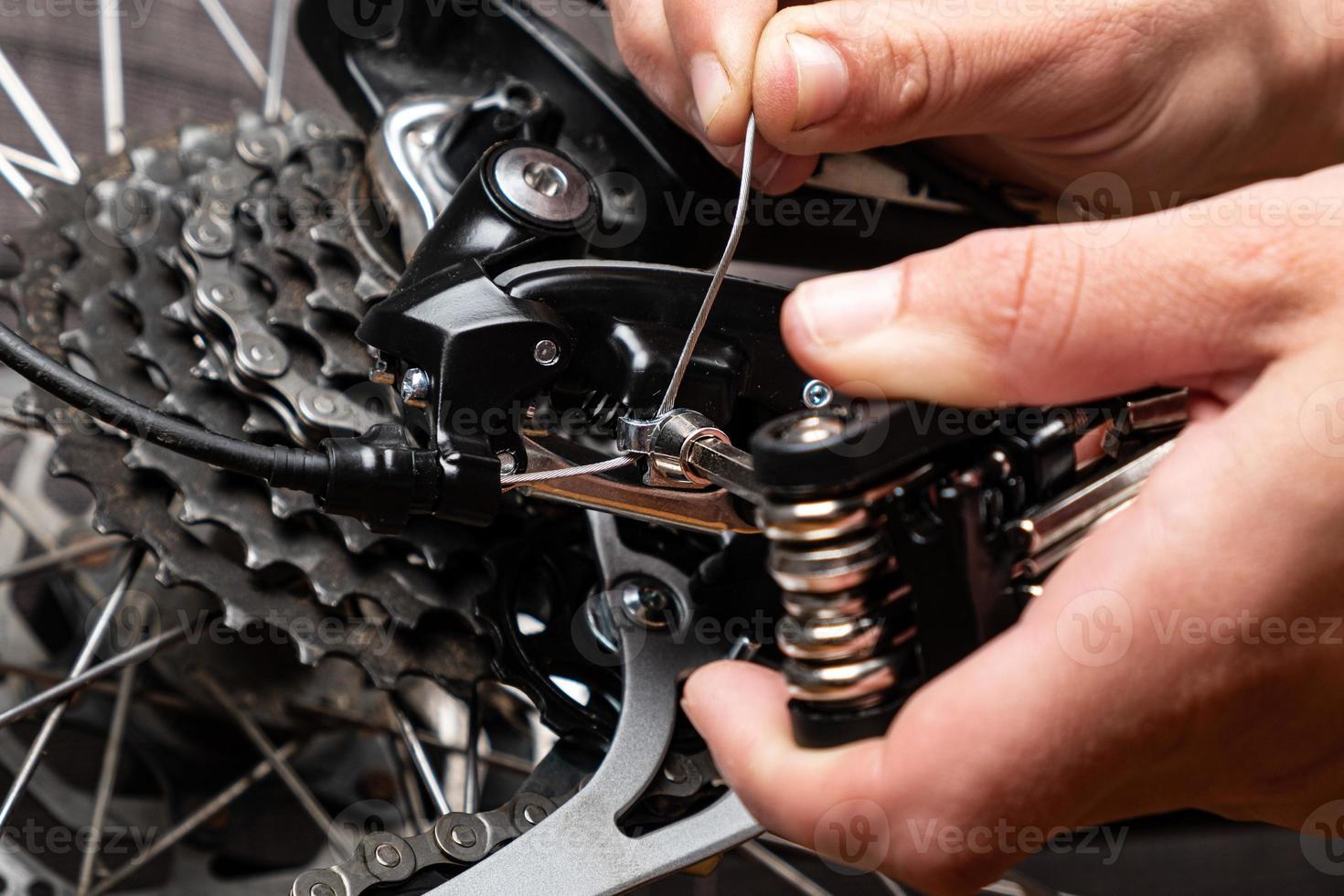 Festziehen des Schaltkabels an einem Fahrrad mit Multitool. foto