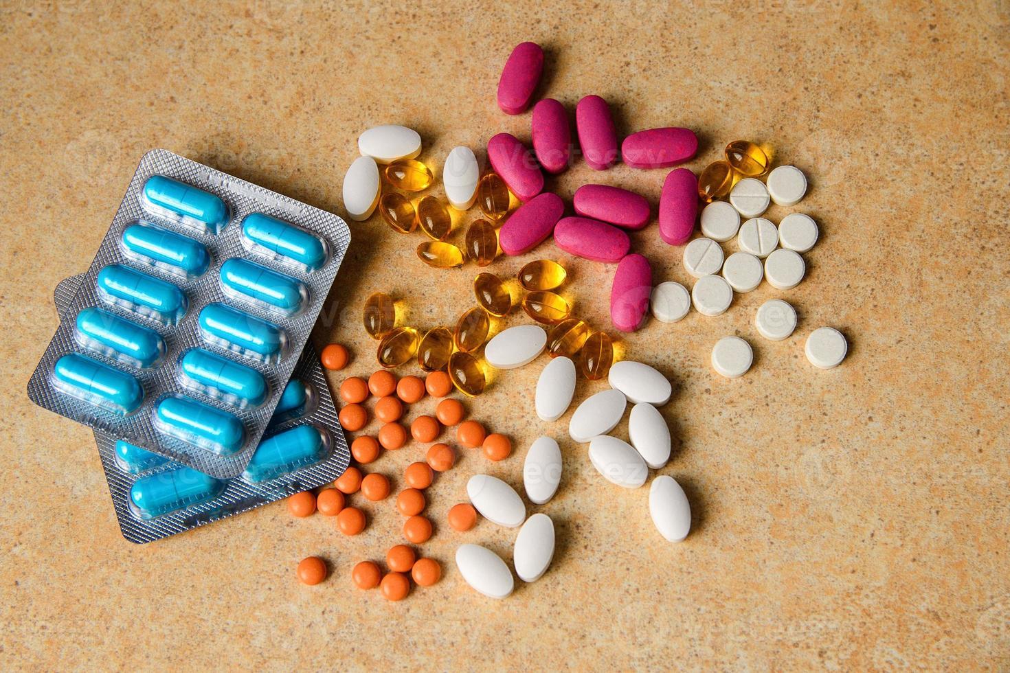 Blister mit blauen, rosa und orangefarbenen Pillen, Vitamin, Fischölkapseln foto