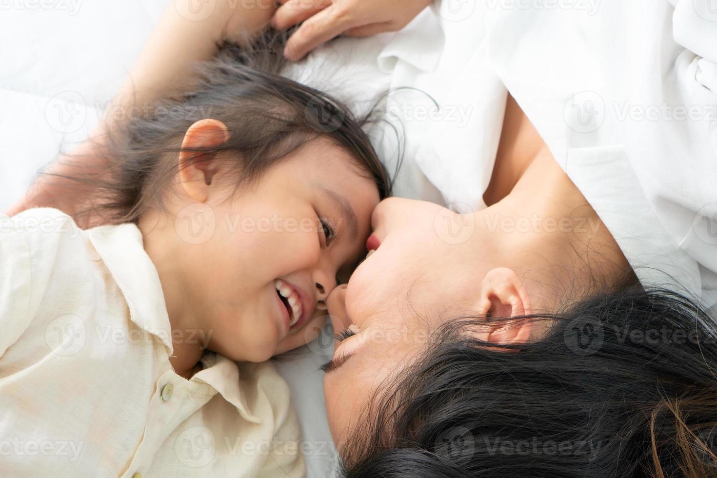 Mutter und Tochter liegen auf einem Bett foto