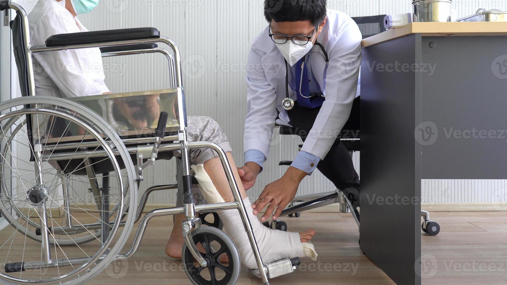 Arzt untersucht gebrochenes Bein foto