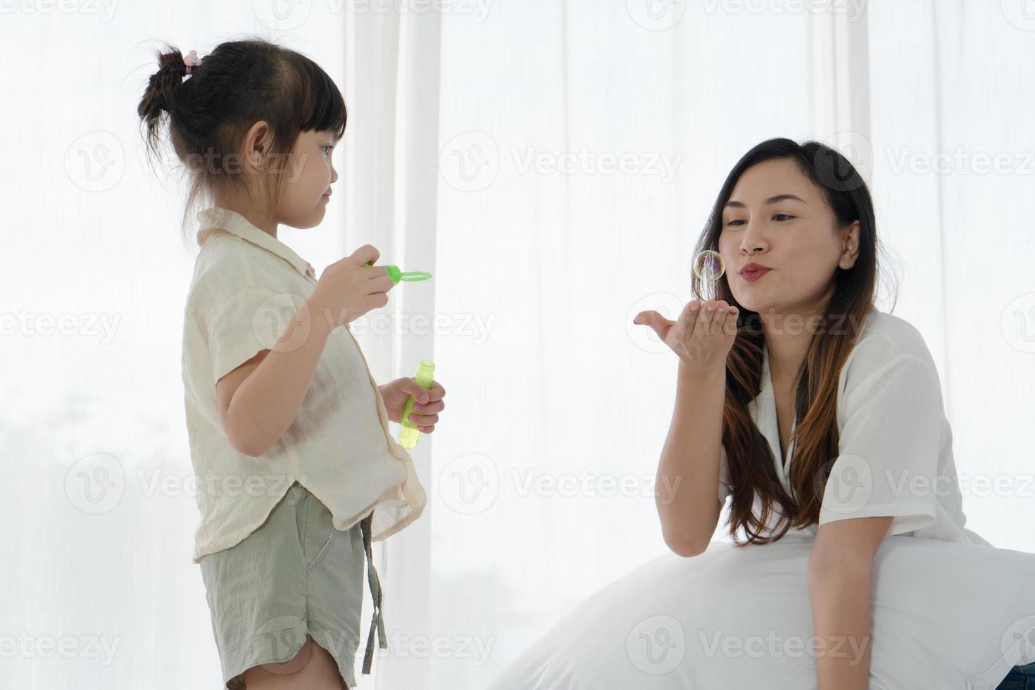 Mutter und Kind bläst Seifenblasen foto