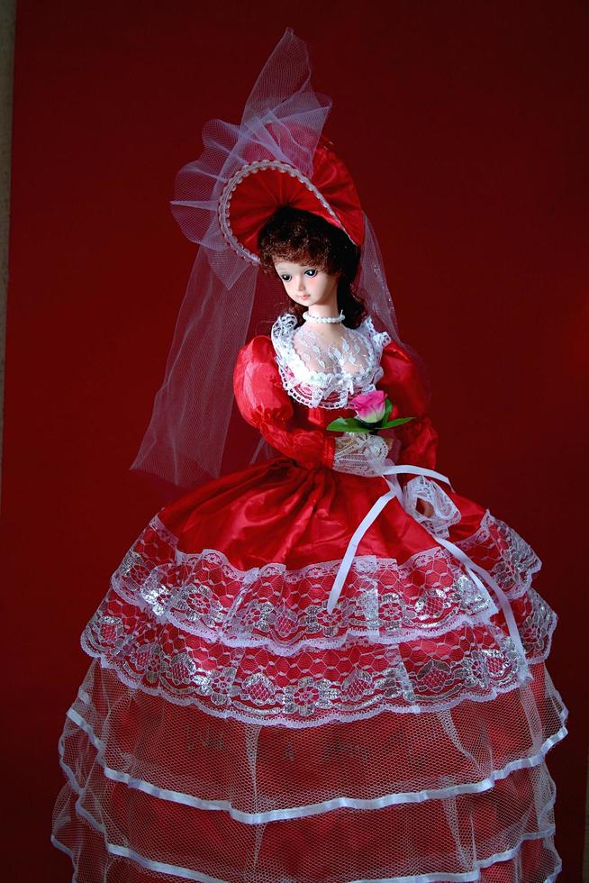 eine bezaubernde und anmutige Puppe mit knallrotem Brautkleid foto