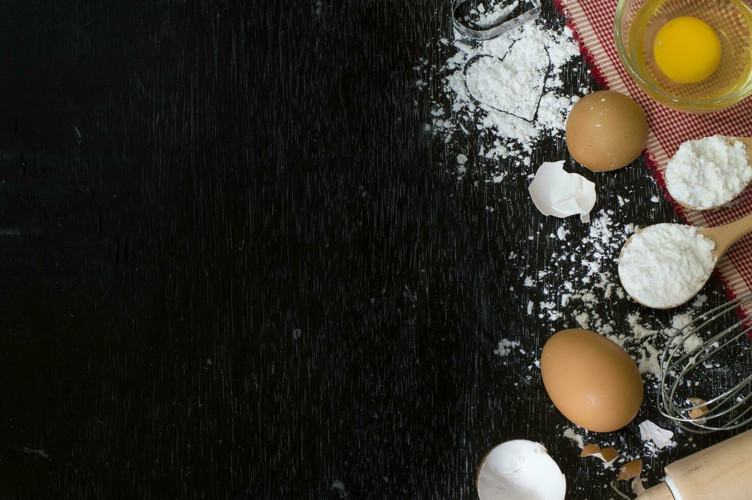 Mehl im hölzern Löffel und Eierschale auf hölzern Tabelle zum Backen Hintergrund foto