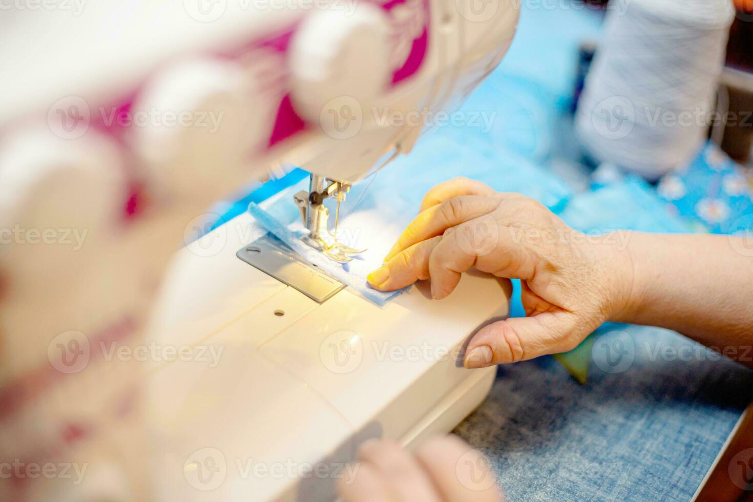 Nähen hausgemacht schützend medizinisch Maske im Verfahren. Frau hält ein Spinnvlies, SMS, schmelzgeblasen Maske beim heim. Detail Weiß modern Nähen Maschine und dreischichtig Masken. foto