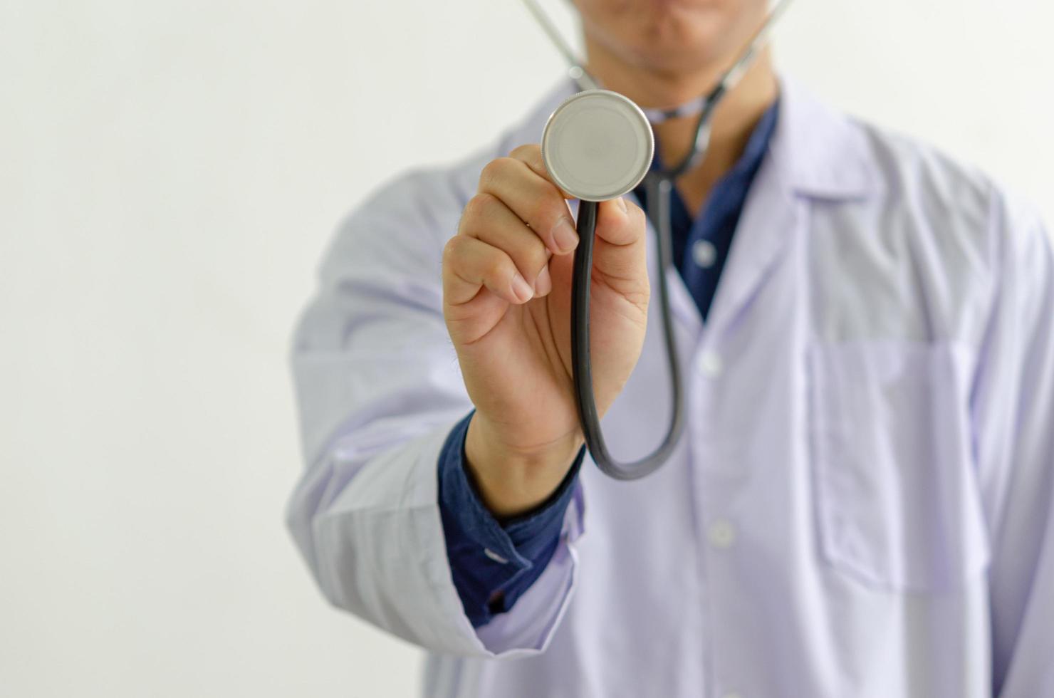 Nahaufnahme der Arzthand, die ein medizinisches Stethoskop hält foto