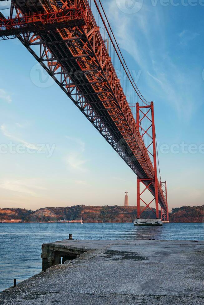 Aussicht von 25 de Abril Brücke Über Tagus Fluss, Christus das König Monument und ein Kai. Lissabon, Portugal foto
