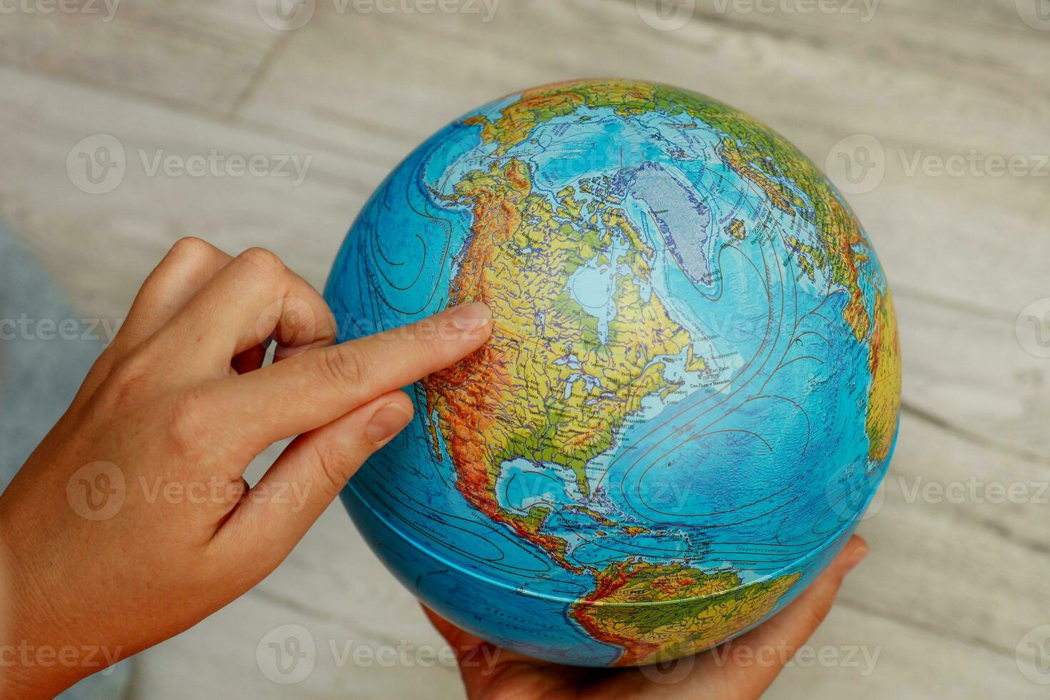 Frau Hand zeigt an Norden Amerika auf das Globus foto