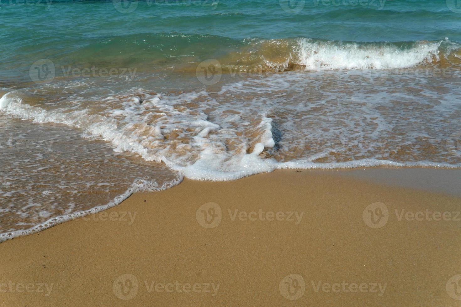 Schaumwelle am Sandstrand. schöne Welle am Strand. foto