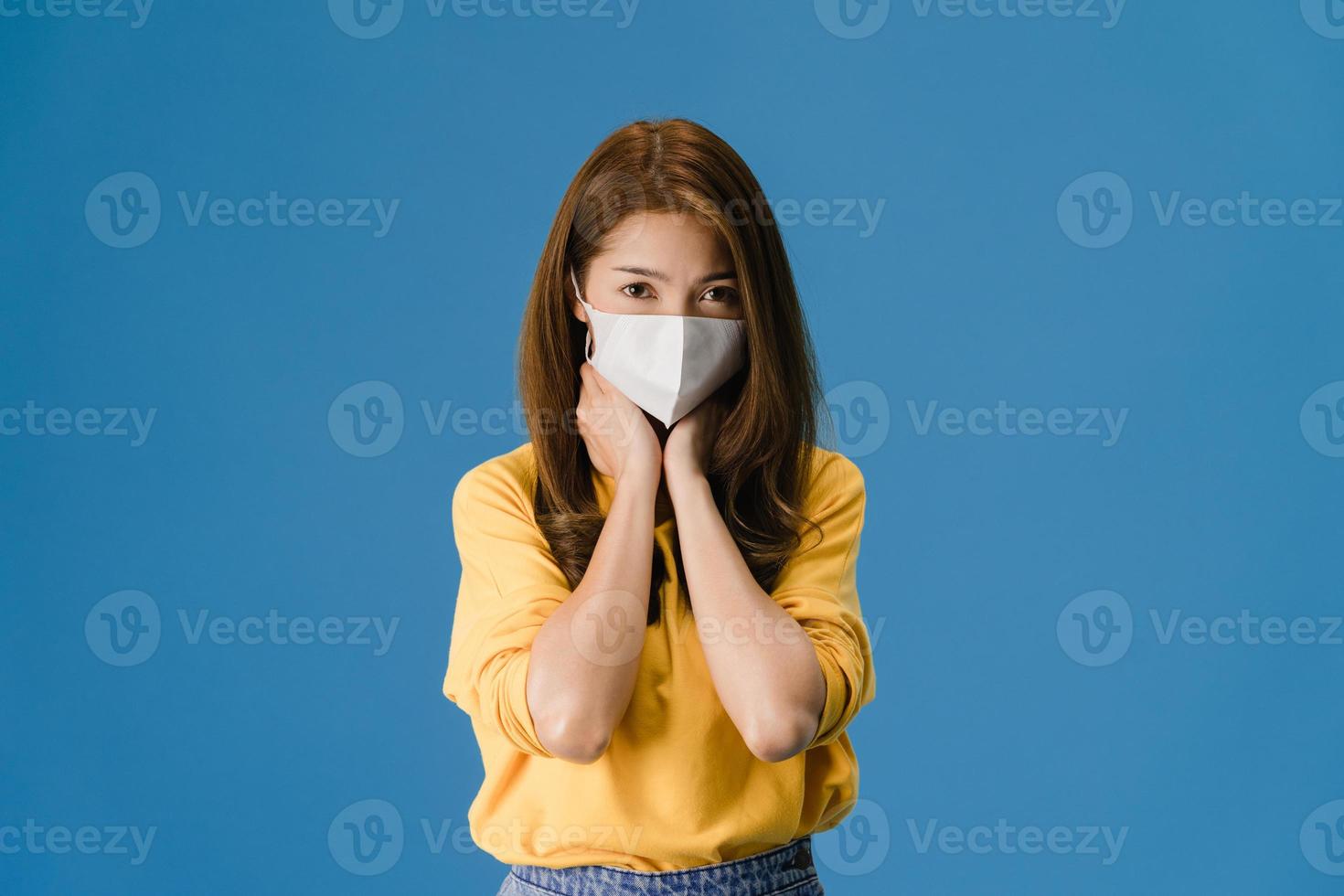 junge asiatische mädchen tragen gesichtsmaske, müde von stress auf blauem hintergrund. foto