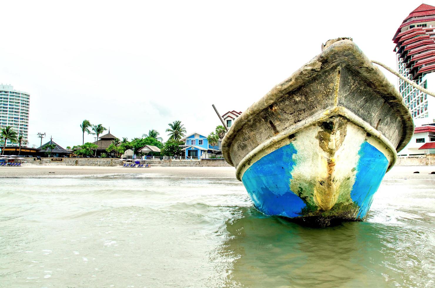 der Sandstrand und das Meer mit dem Boot, das direkt am Strand geparkt ist. foto