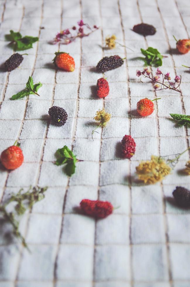 Maulbeerfrüchte und Erdbeeren, frische Beerenfrüchte auf weißem Stoff. foto